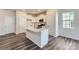 Modern kitchen with white cabinets, quartz island, and hardwood floors at 9744 Inkberry Dr, Gastonia, NC 28056