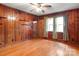 Living room with wood paneled walls, hardwood floors and a brick fireplace at 107 N Thompson St, Shelby, NC 28150