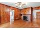 Living room with wood paneled walls, hardwood floors and a brick fireplace at 107 N Thompson St, Shelby, NC 28150