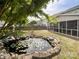 Backyard pond with water lilies, landscaping, and screened-in porch at 1096 Mountain Laurel Ct, Matthews, NC 28104