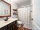Clean bathroom featuring a dark vanity, shower with a curtain, and wood-look flooring at 1096 Mountain Laurel Ct, Matthews, NC 28104