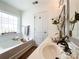Bright bathroom featuring a soaking tub and a double sink vanity with elegant decor at 1096 Mountain Laurel Ct, Matthews, NC 28104