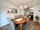 Bright dining room with hardwood floors, large mirror accent, modern light fixture, and seamless flow to the living room at 1096 Mountain Laurel Ct, Matthews, NC 28104
