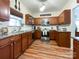 Well-lit kitchen featuring wood cabinets, stainless steel appliances, granite countertops, and hardwood floors at 1096 Mountain Laurel Ct, Matthews, NC 28104