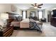 Main bedroom featuring a ceiling fan, carpet flooring, and a large decorative headboard at 1096 Mountain Laurel Ct, Matthews, NC 28104