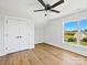 This bedroom features a ceiling fan, hardwood floors, a double door closet, and a window with a view of the outdoors at 4539 Polk Ford Rd, Stanfield, NC 28163