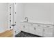 Laundry room with white cabinets, dark hardware, striking dark marble floor, and a long countertop and sink at 4539 Polk Ford Rd, Stanfield, NC 28163