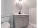 Small bathroom with gray vanity and round mirror at 7039 Executive Cir, Denver, NC 28037