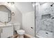 Stylish bathroom with an oval mirror, white vanity, and walk-in shower at 102 S Liberty St, Gastonia, NC 28052