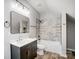 Elegant bathroom with dark vanity, marble tile and bathtub at 102 S Liberty St, Gastonia, NC 28052