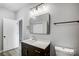 Bathroom with dark vanity, rectangular mirror and toilet at 102 S Liberty St, Gastonia, NC 28052