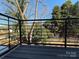 A private balcony featuring a contemporary black railing overlooking lush greenery and trees at 1419 Collier Walk Aly # Csw0208, Charlotte, NC 28205