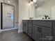 Bathroom featuring gray cabinets, a framed shower with black trim, and sleek tile flooring at 1419 Collier Walk Aly # Csw0208, Charlotte, NC 28205