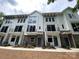 Charming townhome featuring white siding, brick accents, black trim, and private balconies at 1419 Collier Walk Aly # Csw0208, Charlotte, NC 28205