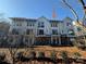 Shot of townhome featuring brick accents, siding, and upper balconies, nestled among the trees at 1419 Collier Walk Aly # Csw0208, Charlotte, NC 28205