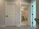 Hallway view showcasing doors leading to a bathroom and other rooms, complemented by neutral tones at 1419 Collier Walk Aly # Csw0208, Charlotte, NC 28205