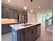 Kitchen with gray cabinets, island with sink, stainless appliances, quartz countertop and pendant lighting at 1419 Collier Walk Aly # Csw0208, Charlotte, NC 28205