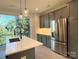 Contemporary kitchen features gray cabinetry, stainless steel appliances, and an island with a breakfast bar at 1419 Collier Walk Aly # Csw0208, Charlotte, NC 28205