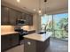 Modern kitchen with gray cabinetry, quartz countertop island, pendant lights, stainless appliances, and sliding glass doors at 1419 Collier Walk Aly # Csw0208, Charlotte, NC 28205