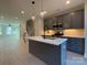 Kitchen with gray cabinets, stainless appliances, pendant lighting over a central island, quartz countertop at 1419 Collier Walk Aly # Csw0208, Charlotte, NC 28205