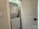A conveniently located laundry room equipped with a stacked washer and dryer unit at 1419 Collier Walk Aly # Csw0208, Charlotte, NC 28205