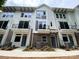 Modern townhomes with white siding, brick accents, Juliet balconies, and well-maintained landscaping at 1421 Collier Walk Aly # Csw0209, Charlotte, NC 28205