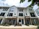 Exterior of new construction townhomes featuring white siding, brick facade, and dark-framed windows at 1421 Collier Walk Aly # Csw0209, Charlotte, NC 28205