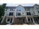 Modern townhouse with a mix of brick and siding, featuring black metal balconies, ample windows, and a welcoming entrance at 1421 Collier Walk Aly # Csw0209, Charlotte, NC 28205