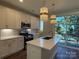 Stylish kitchen featuring white cabinets, stainless steel appliances, a spacious island with gold fixtures and outdoor views at 1421 Collier Walk Aly # Csw0209, Charlotte, NC 28205