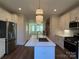 Open concept kitchen with island, stainless steel appliances, and white cabinets at 1421 Collier Walk Aly # Csw0209, Charlotte, NC 28205