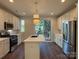 Modern kitchen with white cabinets, stainless steel appliances, kitchen island, and a view to the outdoor balcony at 1421 Collier Walk Aly # Csw0209, Charlotte, NC 28205
