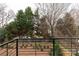 A backyard view from a balcony overlooking a planting bed, trees, and a neighbor's pool at 1425 Collier Walk Aly # Csw0211, Charlotte, NC 28205