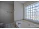 Bright bathroom featuring a soaking tub with unique glass block window at 117 Eagle Ct, Mooresville, NC 28117