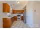 Well-lit kitchen features wood cabinets, stainless steel appliances, granite countertops, and tile flooring at 117 Eagle Ct, Mooresville, NC 28117