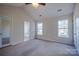 Large bedroom featuring neutral carpet, large windows, vaulted ceilings, and access to a bathroom and closet at 117 Eagle Ct, Mooresville, NC 28117