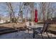 Concrete patio featuring an outdoor table with chairs under a red umbrella overlooking the backyard and mature trees at 117 Eagle Ct, Mooresville, NC 28117