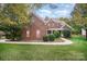 Brick two-story house with landscaped lawn and walkway at 2111 Priory Ct, Charlotte, NC 28262