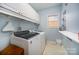 Bright laundry room with washer, dryer, and overhead cabinets at 2111 Priory Ct, Charlotte, NC 28262