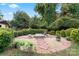 Landscaped backyard with fire pit, stone path, and lush greenery at 138 Wyanoke Ave, Charlotte, NC 28205