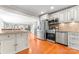 Well-lit kitchen featuring stainless steel appliances, mosaic backsplash, granite countertops, and an island with a sink at 138 Wyanoke Ave, Charlotte, NC 28205