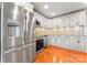 Bright kitchen with stainless steel refrigerator, oven, dishwasher, granite countertops, mosaic backsplash, and wood floors at 138 Wyanoke Ave, Charlotte, NC 28205