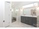 Bright bathroom featuring double vanity with gray cabinets, a walk-in shower, and marble floors at 3452 Airlie St, Charlotte, NC 28205