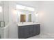 Bright bathroom featuring double vanity with gray cabinets, a walk-in shower, and marble floors at 3452 Airlie St, Charlotte, NC 28205