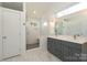 Bright bathroom featuring vanity with gray cabinets, a walk-in shower, and marble floors at 3452 Airlie St, Charlotte, NC 28205