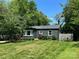 Well-maintained home with a lush green lawn and mature trees, painted in stylish, dark color at 3452 Airlie St, Charlotte, NC 28205