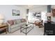 Sunlit living room with neutral color scheme, cozy seating, and large window view at 3452 Airlie St, Charlotte, NC 28205