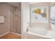 Bright bathroom featuring a soaking tub, separate shower, and a window view at 6003 Hawk View Rd, Waxhaw, NC 28173
