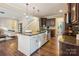 Open kitchen with granite countertops, stainless steel appliances, and dark wood cabinets at 6003 Hawk View Rd, Waxhaw, NC 28173