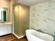 Bright bathroom featuring a modern tub, glass shower, and marble tile at 1168 Queens Rd, Charlotte, NC 28207