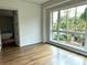 Light-filled bedroom with hardwood floors and a large window overlooking lush greenery at 1168 Queens Rd, Charlotte, NC 28207